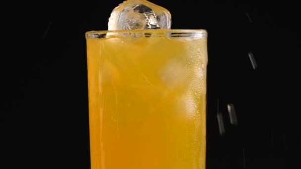 Cola con hielo y burbujas en vidrio giran sobre negro — Vídeos de Stock