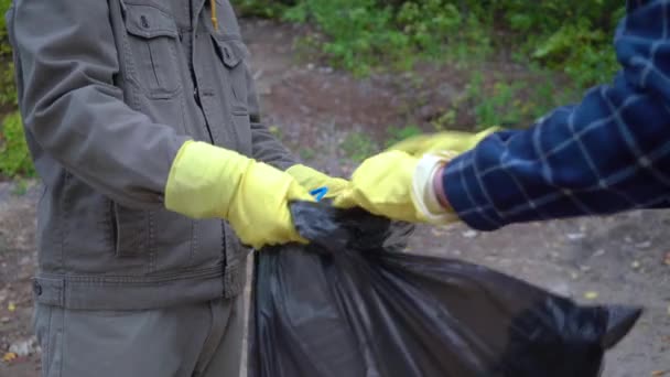 Voluntarios con bolsas de basura limpiando el bosque — Vídeo de stock