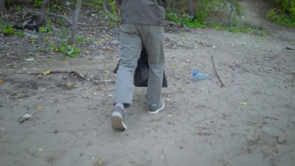 Voluntarios con bolsas de basura limpiando el bosque — Vídeo de stock