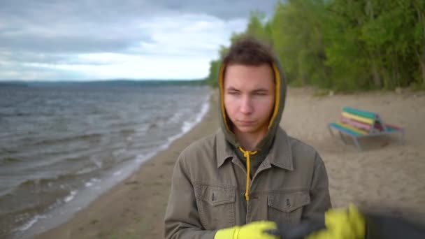 Önkéntesek gyűjtése szemetet egy magányos strandon — Stock videók