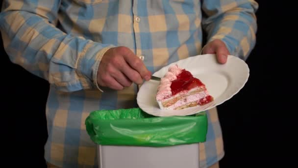 Hombre raspando con un plato un pastel de fresa en el cubo de basura — Vídeo de stock