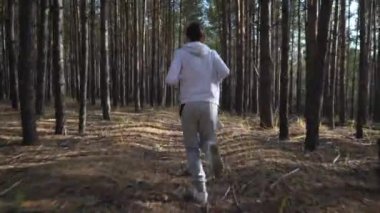 Genç zinde çocuk orman yolunda koşuyor.