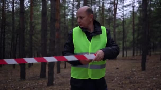 Group of volunteers in green vests went in search of missing persons in a pine forest — Stock Video