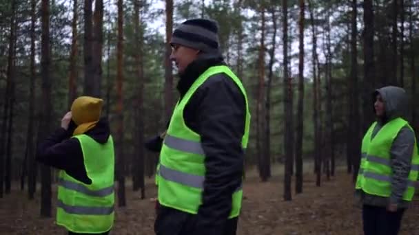 Skupina dobrovolníků v zelených vestách se vydala hledat pohřešované osoby v borovém lese — Stock video