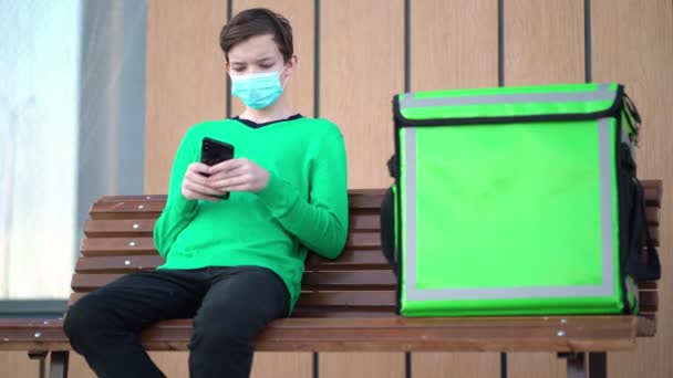 Delivery man with green bagpack awaiting the order for delivery — Stock Video