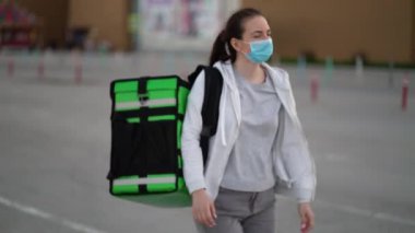 Tıbbi maske takan genç kurye siparişi müşterilere ulaştırıyor.