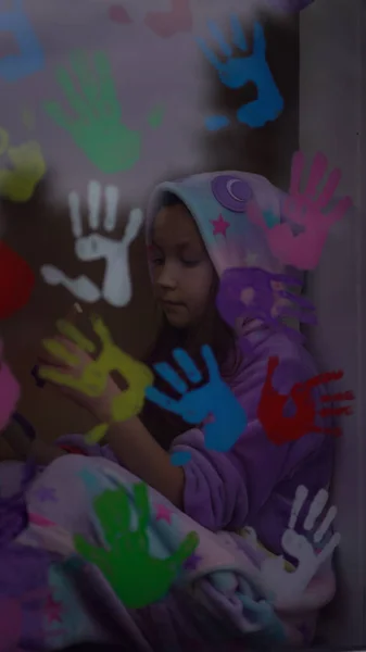 Menina da escola em pijama pintar com palmas na janela . — Fotografia de Stock