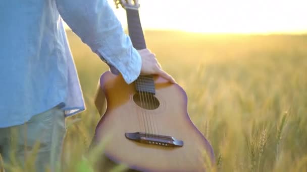 Jovem Caminhando com Guitarra no Campo de Trigo . — Vídeo de Stock