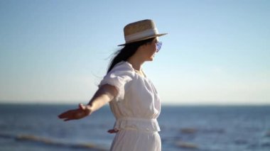 Kollarını kaldırıp denize bakan bir kadın gezgin.