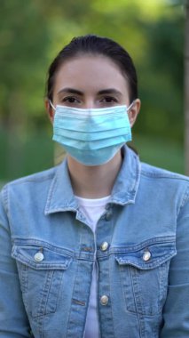 Salgın, dışarıda koruyucu maske takan genç bir kadının portresi. İkinci dalga koronavirüs karantinası