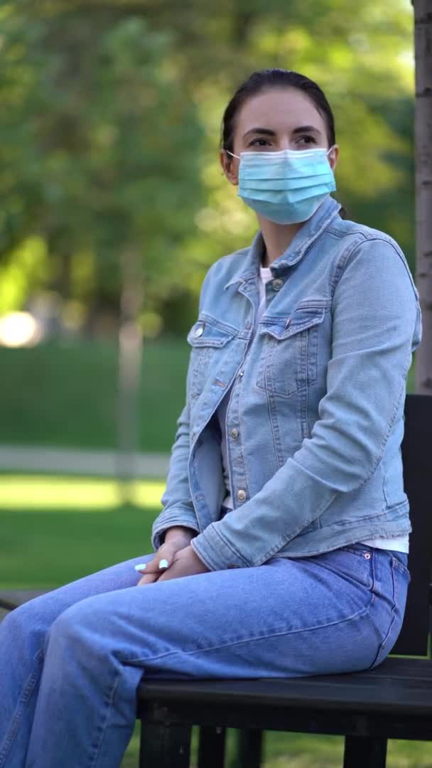 Πανδημία, νεαρή γυναίκα που φοράει προστατευτική μάσκα έξω. Καραντίνα του δεύτερου κύματος κορωναϊού — Αρχείο Βίντεο
