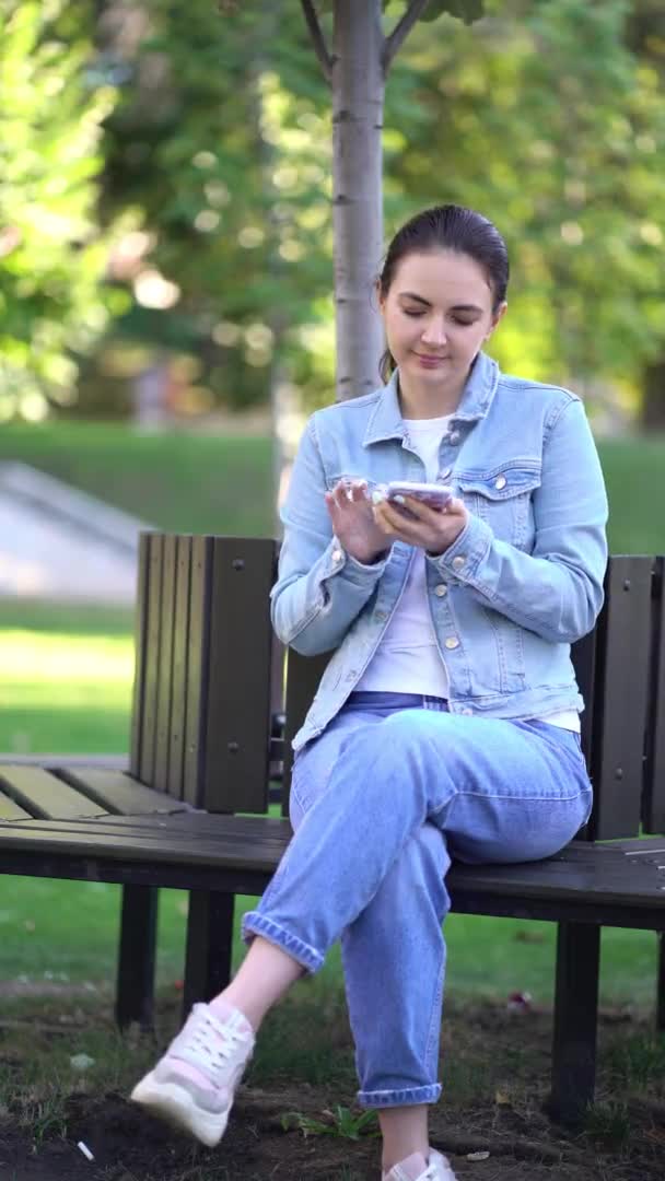 Kvinna Chattar På Smartphone i parken. — Stockvideo