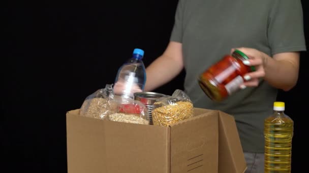 Volunteer putting food in a donation box. Charity concept — Stock Video