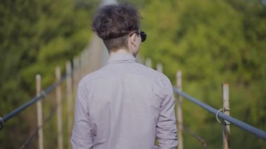 Adam ormanda köprüde yürüyor.