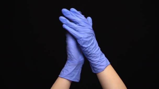 Medische handen met blauwe handschoenen klappen op zwarte achtergrond — Stockvideo