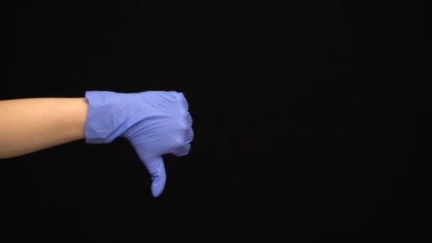 Tangan perempuan dalam sarung tangan medis lateks membuat gerakan yang tidak seperti terisolasi pada latar belakang hitam — Stok Video