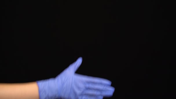 Люди тремтять руками в медичних рукавичках на чорному тлі — стокове відео