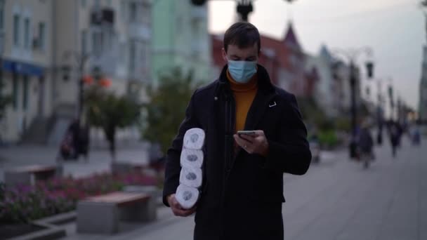 Männer in medizinischer Maske mit Toilettenpapier und Smartphone während der zweiten Quarantäne-Welle der Coronavirus-Pandemie COVID-19 — Stockvideo