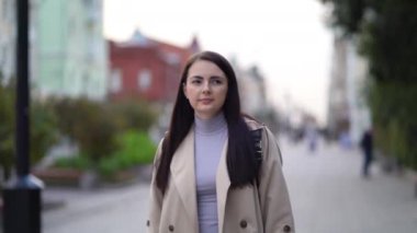 Şehir merkezinde yürüyen genç ve çekici bir iş kadını mutlu bir moda kızı gibi.