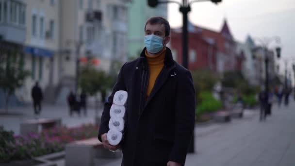 Männer gehen in medizinischer Maske mit Toilettenpapier während der zweiten Quarantäne-Welle des Coronavirus COVID-19 Pandemie — Stockvideo