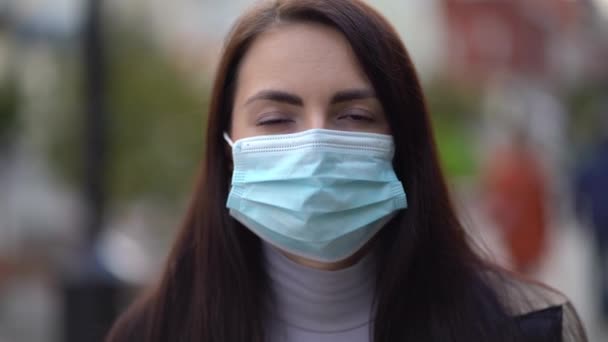 Portret van een gemengde vrouw in de straten van de stad overdag, met een gezichtsmasker tegen de tweede golf quarantaine coronavirus COVID-19 pandemie — Stockvideo
