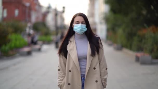 낮에 도시 거리에서 두 번째 파도 검역 코로나 바이러스 (coronavirus) COVID-19 전염병에 얼굴 마스크를 쓰고 있는 혼합 인종 여성의 모습 — 비디오