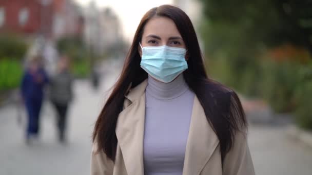 Portret van een gemengde vrouw in de straten van de stad overdag, met een gezichtsmasker tegen de tweede golf quarantaine coronavirus COVID-19 pandemie — Stockvideo