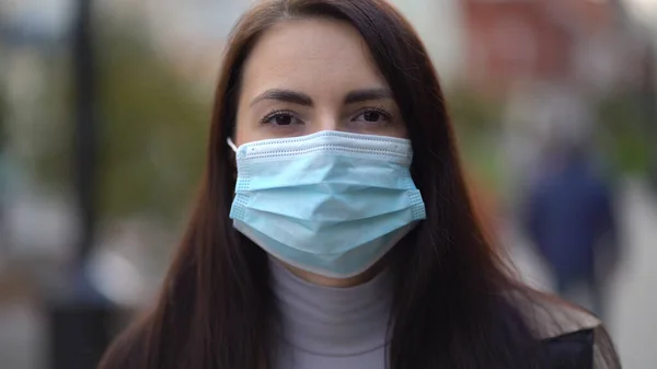 Ritratto di una donna di razza mista per le strade della città durante il giorno, con indosso una maschera facciale contro la seconda ondata di quarantena coronavirus pandemia COVID-19 — Foto Stock