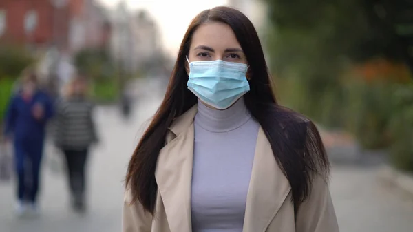 Ritratto di una donna di razza mista per le strade della città durante il giorno, con indosso una maschera facciale contro la seconda ondata di quarantena coronavirus pandemia COVID-19 — Foto Stock