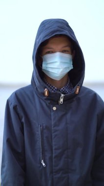 Çocuk tıbbi maskesi ikinci dalga karantina sırasında sahilde duruyor. Coronavirus COVID-19 salgını sırasında.