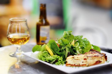 Geleneksel Fransız yemekleri: quiche lorraine ve taze salata yaprakları bardak bira. Sağlıklı yemek. Öğle veya akşam yemeği ile organik sebze. Tipik Avrupa yerel çiftçi pazarı