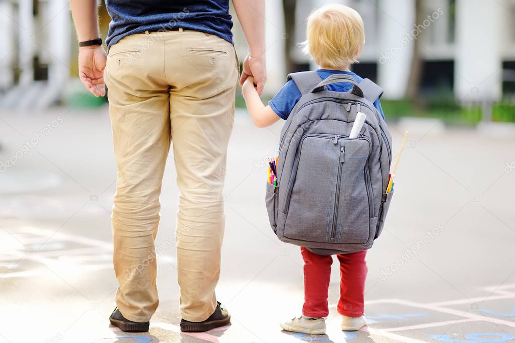 Back to school concept. Little pupil with his father. First day of primary school. Education for small kids.