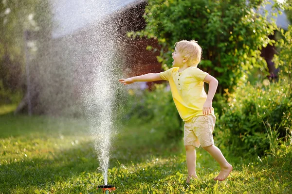 Ragazzino Divertente Che Gioca Con Irrigatore Giardino Nel Cortile Soleggiato — Foto Stock