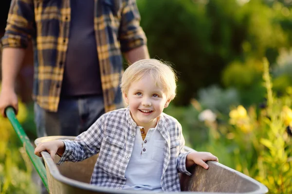 Щасливий Маленький Хлопчик Розважається Інвалідному Візку Штовхаючи Тата Домашній Сад — стокове фото