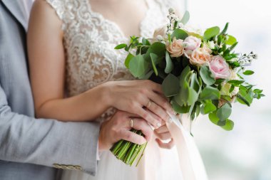 Gelin ve damadın nikah yüzükleri elleriyle. Şık düğün buket holding yeni evli çift