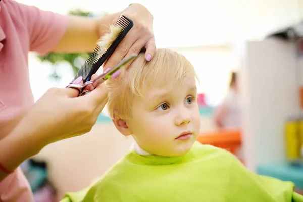 未就学児は散髪する 専門的なツールを持つ子供の美容師 櫛とはさみ 子供のためのカット髪 — ストック写真
