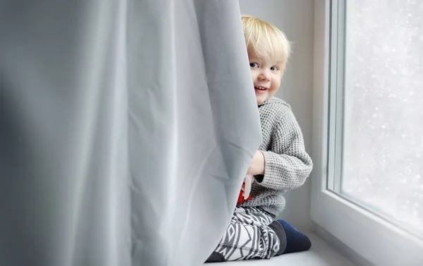 蹒跚学步的男孩在家里的窗台上玩 — 图库照片
