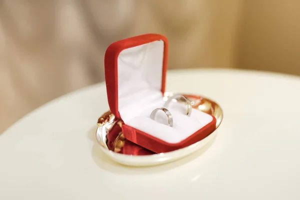 Dva Svatební Prsteny Bílého Zlata Bílém Polštáři Červeném Poli Během — Stock fotografie