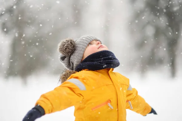 Ładny Mały Chłopiec Żółte Zimowe Ubrania Spacery Podczas Opadów Śniegu — Zdjęcie stockowe