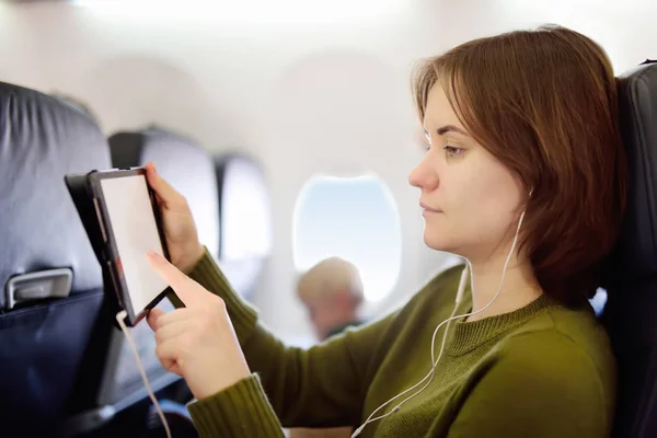 Una Joven Viajando Avión Persona Que Utiliza Tableta Escuchar Una — Foto de Stock