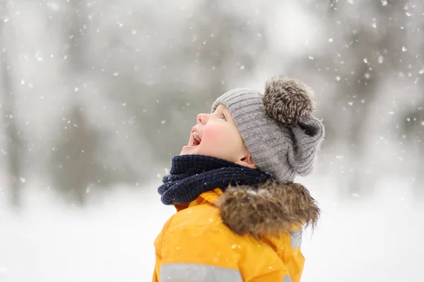 Netter Kleiner Junge Gelber Winterkleidung Geht Bei Schneefall Spazieren Winteraktivitäten — Stockfoto