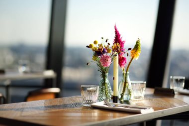 Vazo ve mum çiçekleri ile bir kafe veya restoranda Masa. Catering.