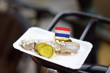 Amsterdam, Hollanda bisiklet bagajında soğan ve salatalık ile ünlü ringa balığı. Geleneksel Hollanda yemekleri.