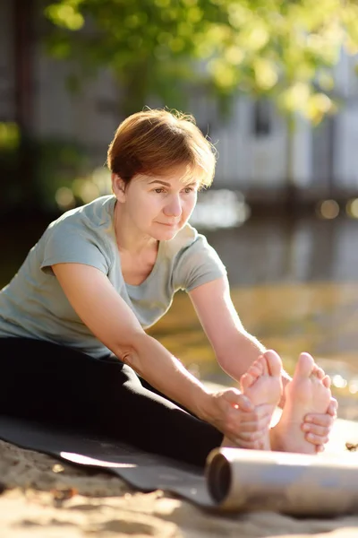 Mogen Kvinna Öva Yoga Utomhus Övning Stranden Nära Floden Hälsosam — Stockfoto