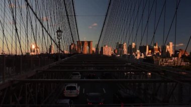 Araba sürme ve yayalar Brooklyn Köprüsü üzerinde günbatımında yürümek. New York City'e Brooklyn köprüsüne Brooklyn.