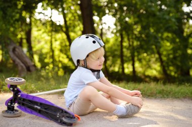 Yürümeye başlayan çocuk kask scooter binmek için öğrenme. Çocuk kask içinde. Güvenlik, spor, eğlence çocuk kavramı ile.