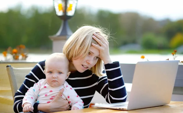 Tired Young Mother Working Her Laptop Holding Month Daughter — Stock Photo, Image