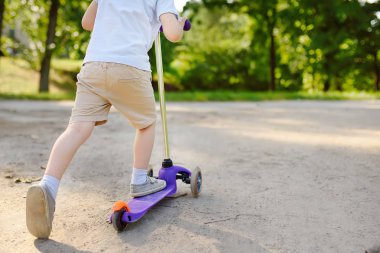 Yürümeye başlayan çocuk scooter binmek için öğrenme. Çocuk kask içinde. Güvenlik, spor, eğlence çocuk kavramı ile.