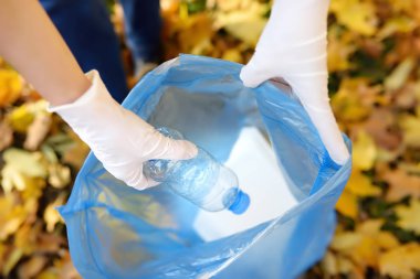 Gönüllü plastik çöp ve açık havada üzerinde biyolojik olarak parçalanabilen çöp kutusuna koyarak. Ekoloji, geri dönüşüm ve doğa kavramı korunması.
