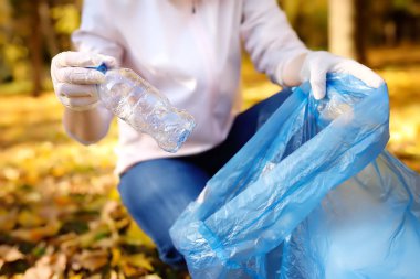 Gönüllü plastik çöp ve açık havada üzerinde biyolojik olarak parçalanabilen çöp kutusuna koyarak. Ekoloji, geri dönüşüm ve doğa kavramı korunması.